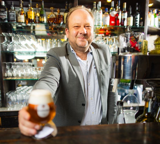 Sebastian Grabosch reicht ein Bier über den Tresen